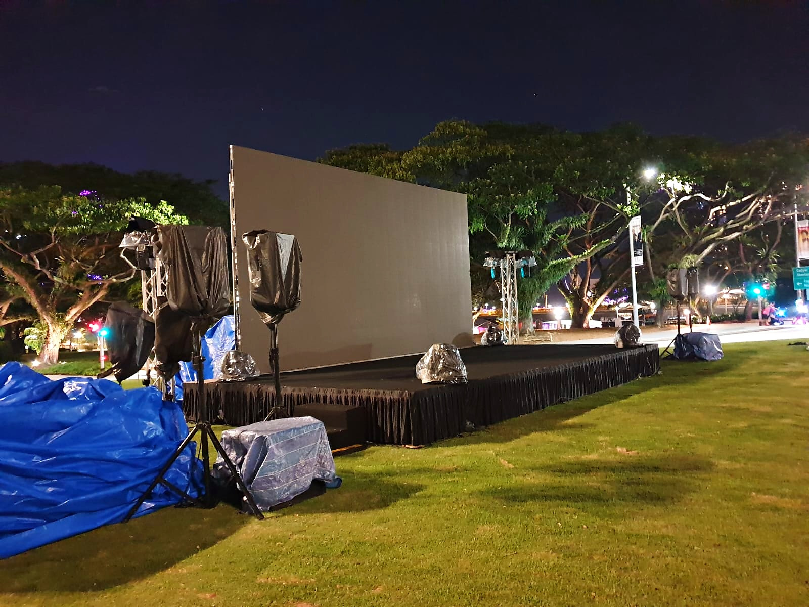 Movie Screening: 6 Easy Ways to Plan Better Seating 3 Outdoor movie screen and covered equipment on a lawn at night