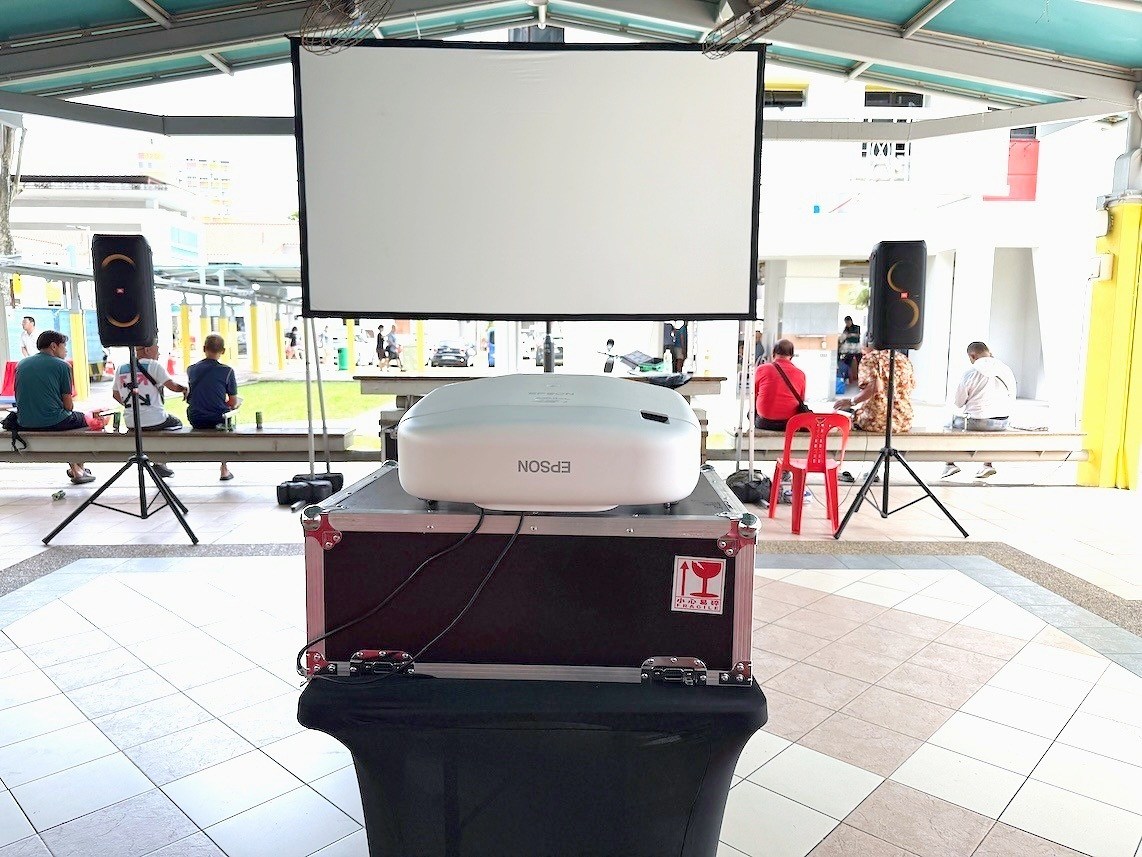 Movie Screening: 6 Easy Ways to Plan Better Seating 9 Projector on a flight case facing a screen under a pavilion roof