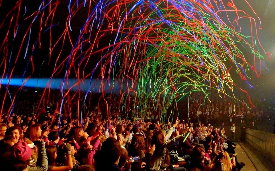 Event Participation: Choosing When Guests Watch, Make and Join In 1 Audience celebrating beneath colourful streamers at an event